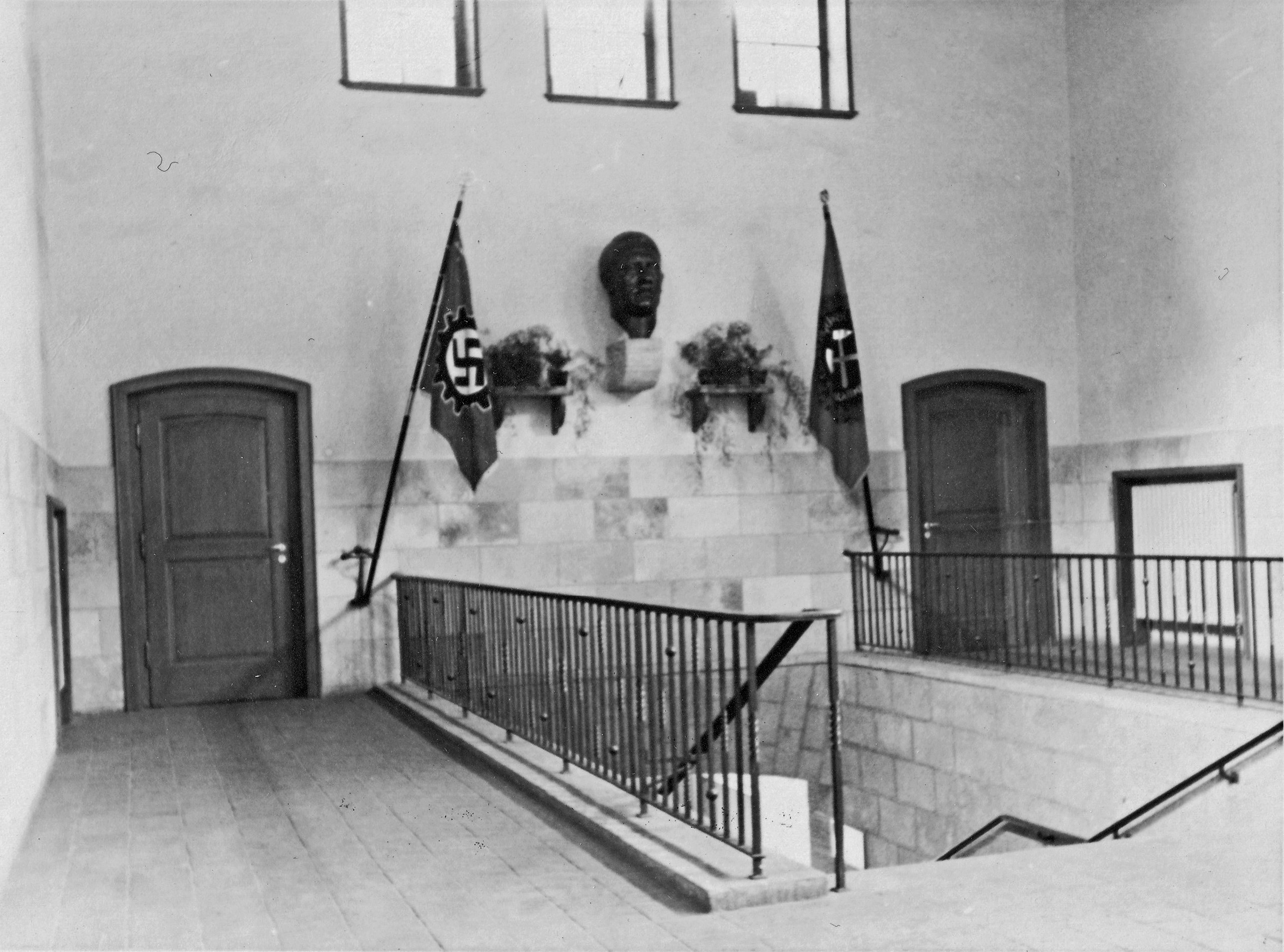 Innenansicht (Nordwand) der Lohnhalle mit der Büste Adolf Hitlers und Beflaggung, 1940